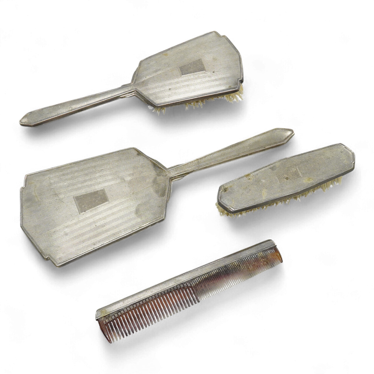 An Elizabeth II engine turned silver Art Deco style four pieced dressing table mirror, brush and comb set, W.I. Broadway & Co, Birmingham, 1961/63/65, mirror 27.8cm.